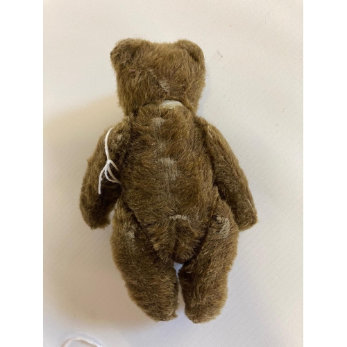 122 - Small Steiff jointed bear, with glass eyes, brown plush, fabric bow and white metal ear button, 5 1/... 