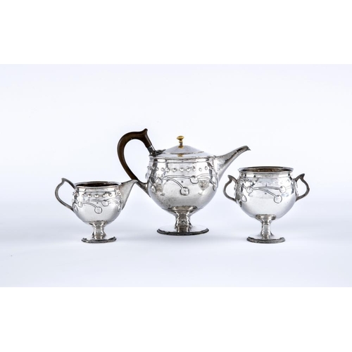 120 - AN EDWARDIAN ARTS AND CRAFTS SILVER THREE PIECE TEA SERVICE, by A E Jones, Birmingham 1910 (sugar) a... 