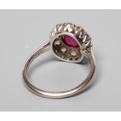 172 - A RUBY AND DIAMOND CLUSTER RING, the oval facet cut ruby claw set to a border of ten brilliant cut d... 