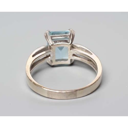 173 - AN AQUAMARINE AND DIAMOND COCKTAIL RING, the step cut aquamarine claw set to plain shoulders each po... 