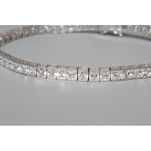 180 - A TENNIS BRACELET, the sixty one cubic zirconia channel set to a plain white frame, stamped 375 (Est... 