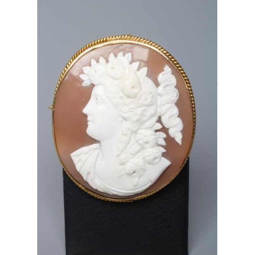 189 - A SHELL CAMEO BROOCH carved with the head and shoulders of a young lady with flowers in her curled h... 