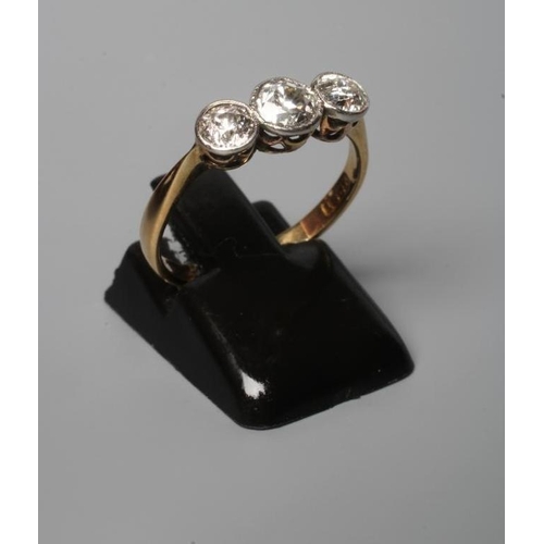 190 - A THREE STONE DIAMOND RING, the old cut stones collet set to a plain shank stamped 18ct, size N (Est... 