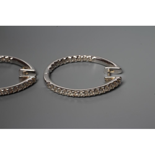 191 - A PAIR OF DIAMOND HOOP EARRINGS, the half hinged rings point set with numerous small stones to the o... 