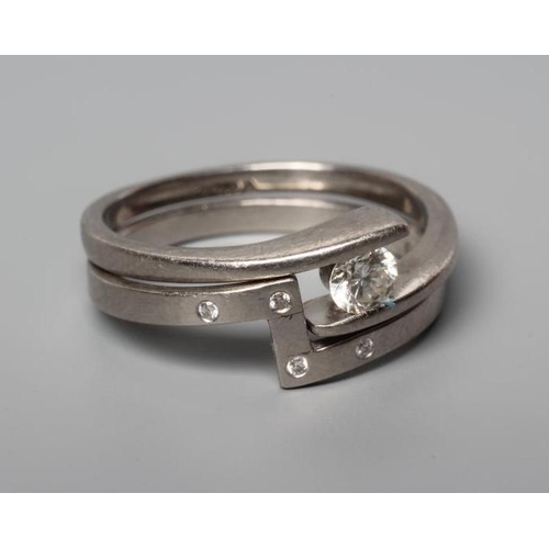 192 - A PALLADIUM DIAMOND ENGAGEMENT AND MATCHING WEDDING RINGS, the modern crossover with a tension set r... 