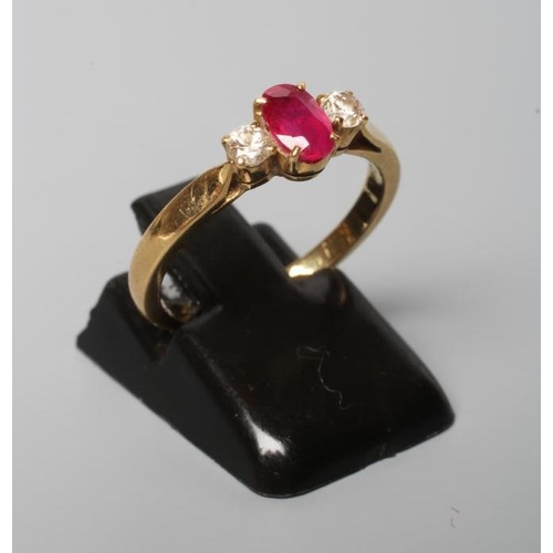 197 - A RUBY AND DIAMOND THREE STONE RING, the central oval facet cut ruby claw set and flanked by two sma... 