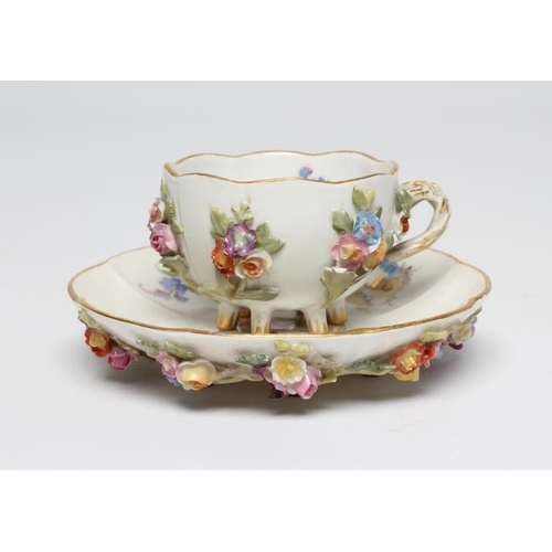 21 - A MEISSEN PORCELAIN CABINET CUP AND SAUCER, late 19th century, of lobed circular form raised upon pe... 