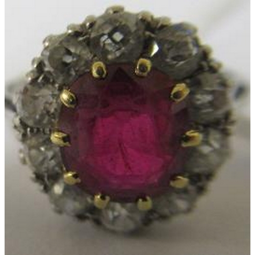 172 - A RUBY AND DIAMOND CLUSTER RING, the oval facet cut ruby claw set to a border of ten brilliant cut d... 