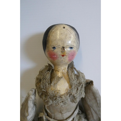 10 - A Victorian peg doll with carved and painted head and torso, cloth upper limbs and carved wooden low... 