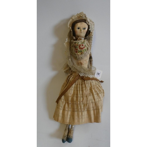 12 - An English wooden doll, c.1800, with carved and painted head and torso, brown wig, brown glass inset... 