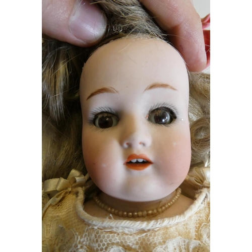 15 - A Wagner & Zetsche bisque shoulder head doll with brown glass fixed eyes, open mouth, teeth, blond w... 