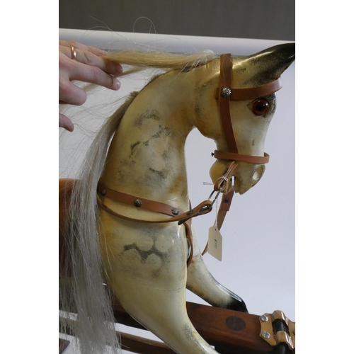 171 - A dappled grey rocking horse, with painted and carved wood body, amber eyes, horse hair mane and tai... 