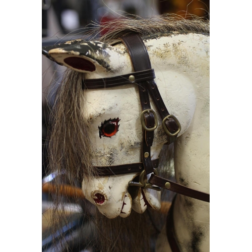 173 - A dappled grey rocking horse, with painted and carved wood body, sideways turning head, amber eyes, ... 