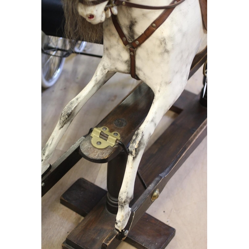 173 - A dappled grey rocking horse, with painted and carved wood body, sideways turning head, amber eyes, ... 