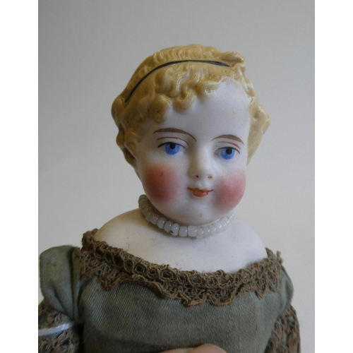 33 - A bisque shoulder head doll, 19th century, with painted features, moulded hair, fabric body, bisque ... 