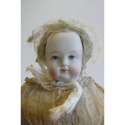 35 - A bisque shoulder head doll, 19th century, with painted features, blond wig, fabric body and china a... 