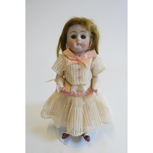 45 - A mignonette all bisque doll, with brown glass sleeping eyes, moulded open mouth, auburn wig, jointe... 