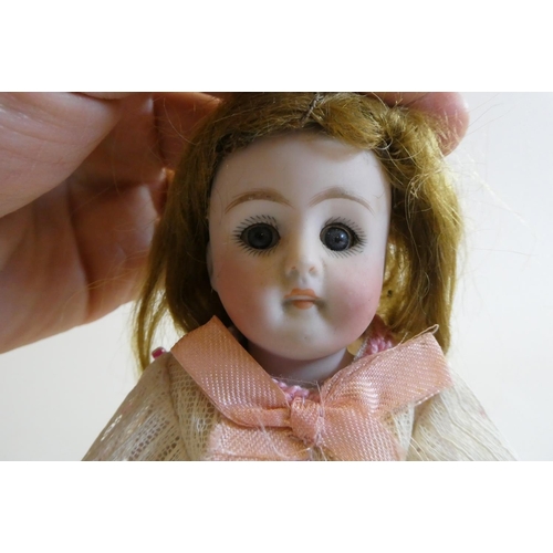 45 - A mignonette all bisque doll, with brown glass sleeping eyes, moulded open mouth, auburn wig, jointe... 