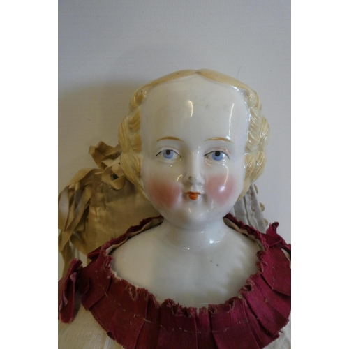 57 - A Victorian china shoulder head doll with painted features, moulded hair, jointed kid body, lace dre... 