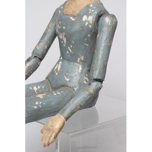 81 - An antique seated Santos doll, of jointed wood and plaster carved construction, polychrome painted a... 