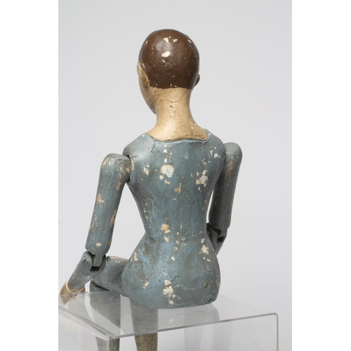 81 - An antique seated Santos doll, of jointed wood and plaster carved construction, polychrome painted a... 