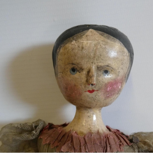 9 - A Victorian peg doll with carved and painted head and torso, cloth upper limbs and carved wooden low... 