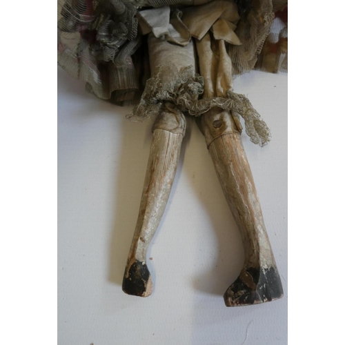 9 - A Victorian peg doll with carved and painted head and torso, cloth upper limbs and carved wooden low... 