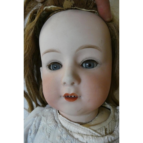 92 - A Heubach bisque socket head doll, with blue glass sleeping eyes, open mouth, applied teeth, auburn ... 