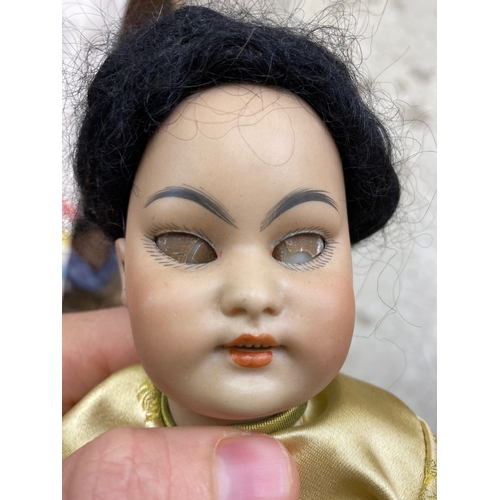 87 - A Simon & Halbig bisque socket head Asian girl doll, with brown glass sleeping eyes, open mouth, tee... 