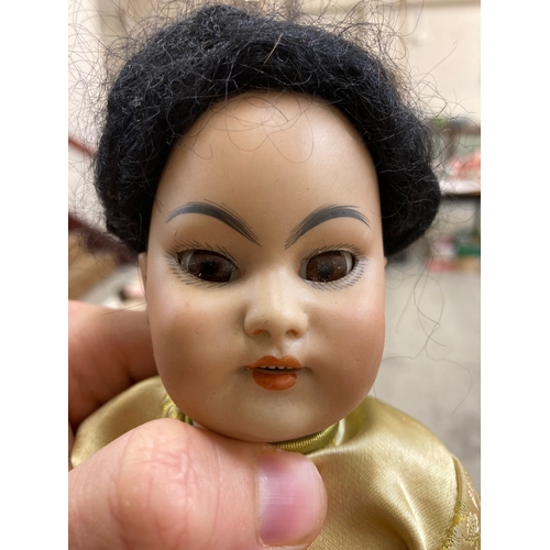 87 - A Simon & Halbig bisque socket head Asian girl doll, with brown glass sleeping eyes, open mouth, tee... 