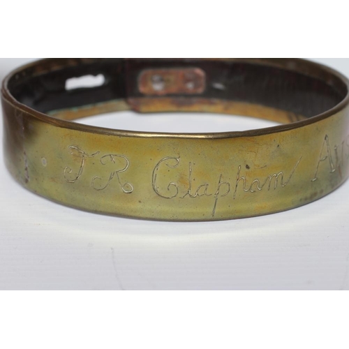 413 - A BRASS DOG COLLAR, early 19th century, engraved 'T R Clapham, Austwick Hall', leather lined, 4 1/2