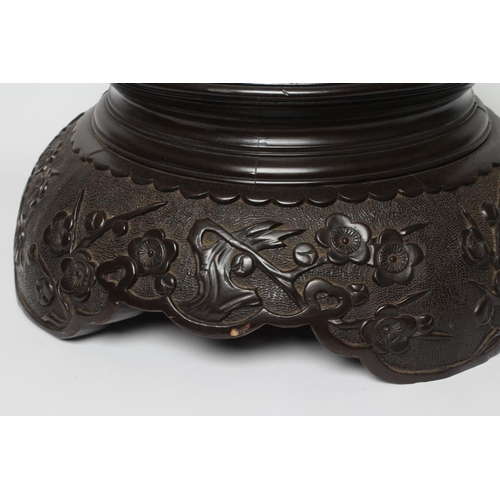 417 - A CARVED CHINESE STAINED WOOD STAND, the incise key carved platform on a domed base similarly carved... 