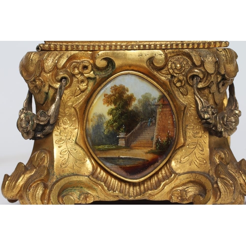 446 - A GILT METAL ROCOCO REVIVAL JEWELLERY CASKET, late 19th century, with inset landscape scenes and red... 