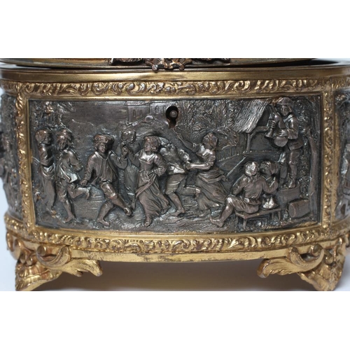 447 - A FRENCH GILDED ORMOLU OVAL JEWELLERY CASKET, late 19th century, with hinged top and medieval scenes... 