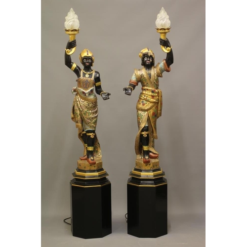 458 - A PAIR OF HAND CARVED POLYCHROME AND GILDED TORCHERE BLACKAMOORS, each full length in costume on pli... 