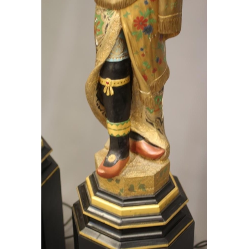 458 - A PAIR OF HAND CARVED POLYCHROME AND GILDED TORCHERE BLACKAMOORS, each full length in costume on pli... 