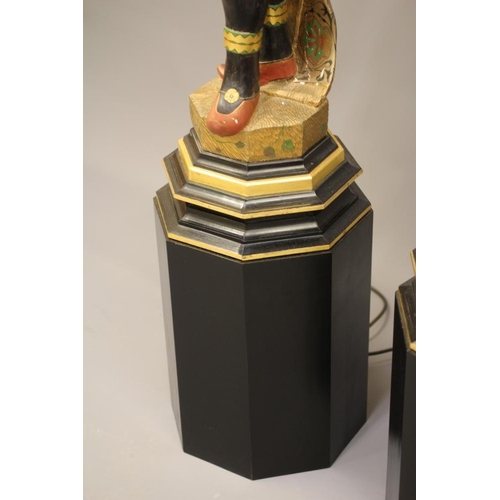 458 - A PAIR OF HAND CARVED POLYCHROME AND GILDED TORCHERE BLACKAMOORS, each full length in costume on pli... 