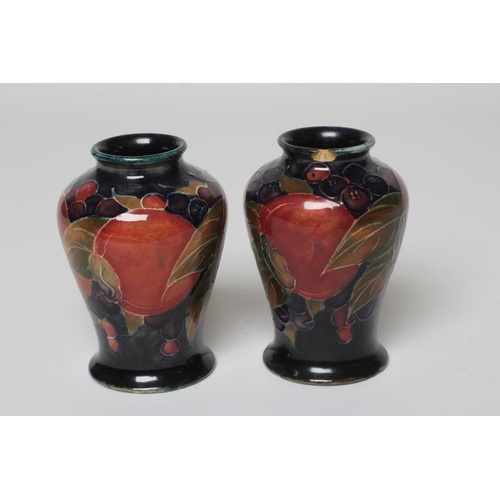 72 - A PAIR OF MOORCROFT POTTERY POMEGRANATE SMALL VASES, c.1915, of inverted baluster form, initialled i... 