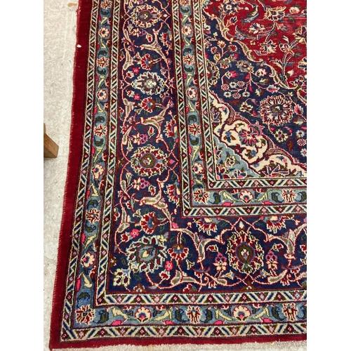 638 - A KASHAN RUG, with central floral medallion on a red ground surrounded by light and dark blue floral... 