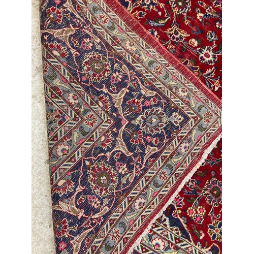 638 - A KASHAN RUG, with central floral medallion on a red ground surrounded by light and dark blue floral... 