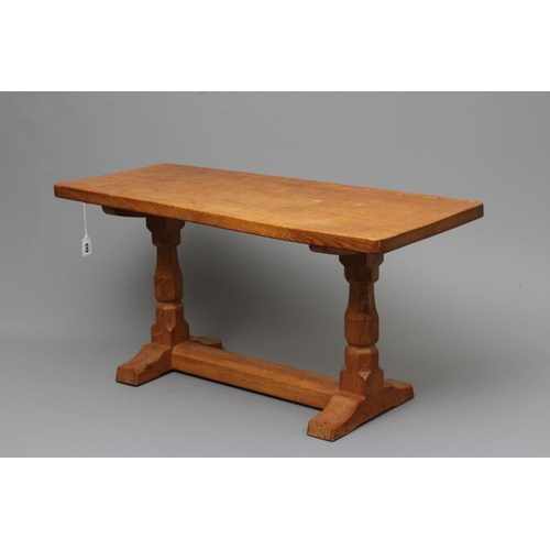 648 - A ROBERT THOMPSON ADZED OAK COFFEE TABLE, the oblong top raised on trestle base with turned faceted ... 