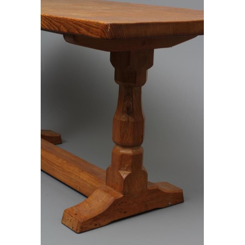 648 - A ROBERT THOMPSON ADZED OAK COFFEE TABLE, the oblong top raised on trestle base with turned faceted ... 