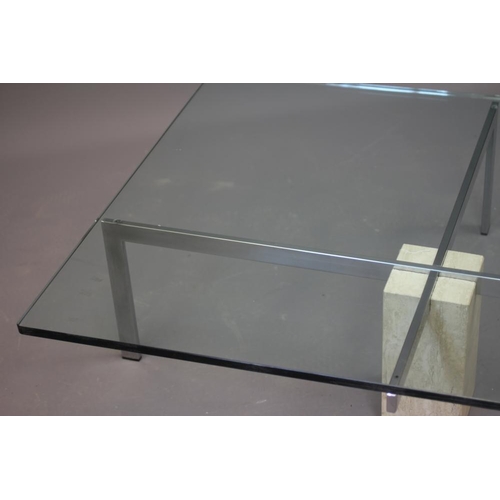 651 - A GLASS AND POLISHED STEEL COFFEE TABLE, modern, the rounded square glass top raised on an X frame s... 