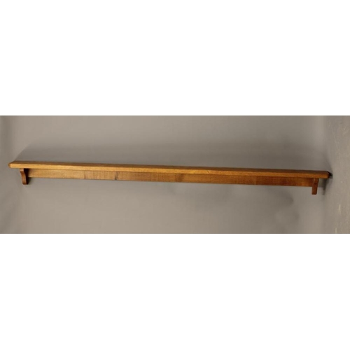 654 - A ROBERT THOMPSON ADZED OAK WALL SHELF of rounded oblong form on ogee end brackets, carved mouse tra... 