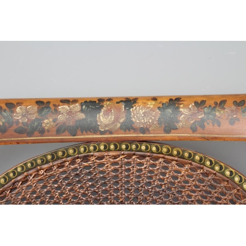 663 - AN EDWARDIAN CANED AND FLORAL PAINTED ELBOW CHAIR, early 20th century, the straight top rail over ov... 