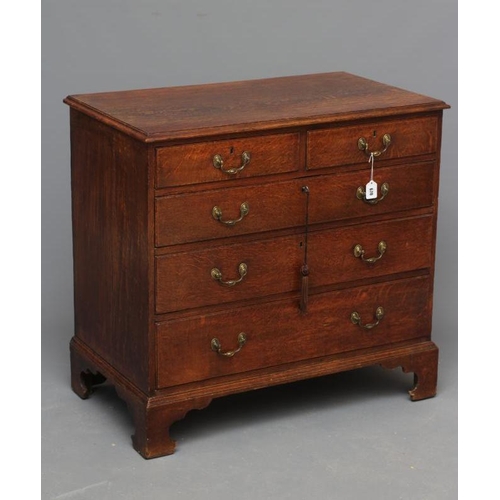 670 - A GEORGIAN OAK STRAIGHT FRONT CHEST, early 19th century, the moulded edged top over two short and th... 