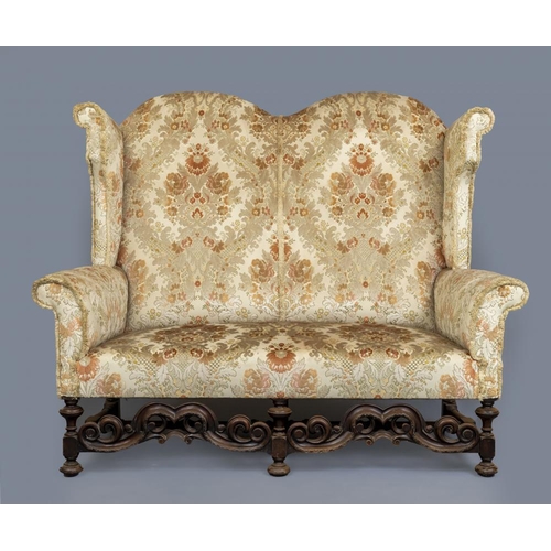 677 - A WILLIAM & MARY STYLE WALNUT FRAMED WING SOFA, early 20th century, upholstered in rust and cream fl... 