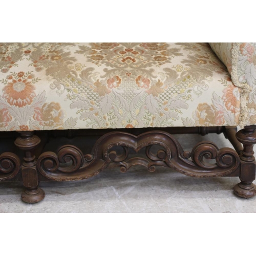 677 - A WILLIAM & MARY STYLE WALNUT FRAMED WING SOFA, early 20th century, upholstered in rust and cream fl... 