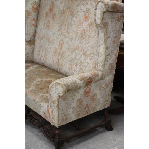 677 - A WILLIAM & MARY STYLE WALNUT FRAMED WING SOFA, early 20th century, upholstered in rust and cream fl... 