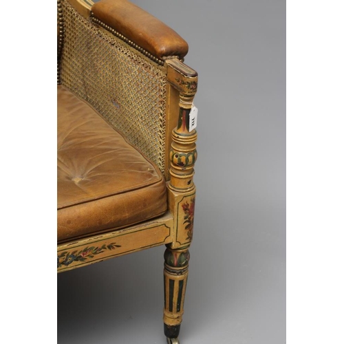 712 - A REGENCY PAINTED MAHOGANY LIBRARY BERGERE, early 19th century, with single caning, the pale brown l... 